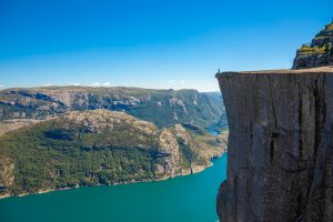 Hiker,Standing,On,Preikestolen,And,Looking,On,The,Fjerd,,Preikestolen